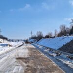 2026_01_27 Wykonywanie narzutu kamiennego wzmacniającego skarpy w km 9+800